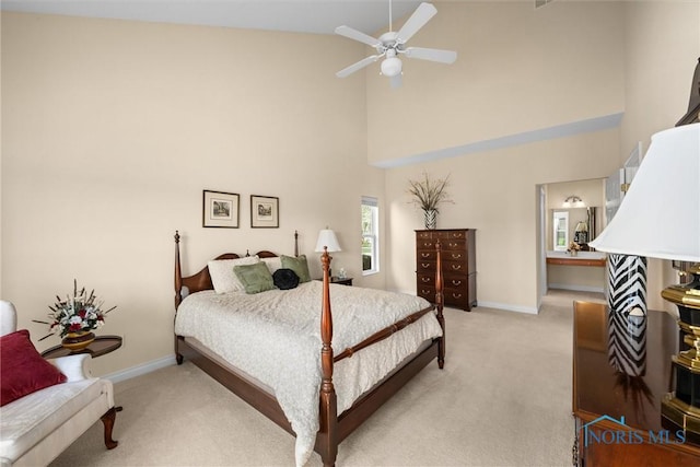 bedroom featuring a ceiling fan, high vaulted ceiling, light carpet, and baseboards