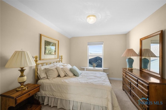 bedroom with light colored carpet and baseboards