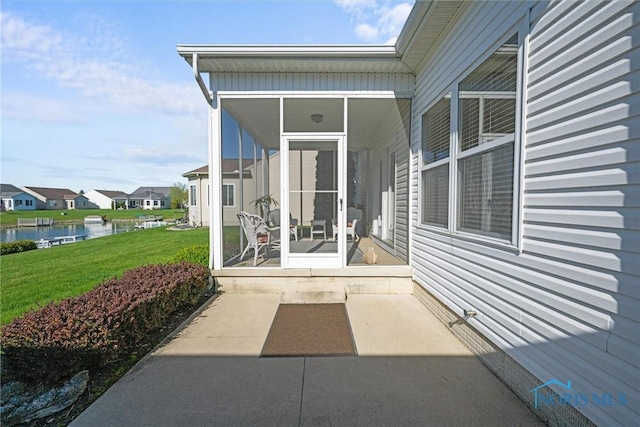 view of patio / terrace featuring a water view, a residential view, and a sunroom