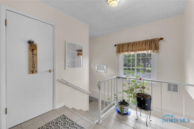 888 Columbus Ave, Fostoria, OH 44830 - stairs featuring tile patterned flooring, a textured ceiling, and visible vents