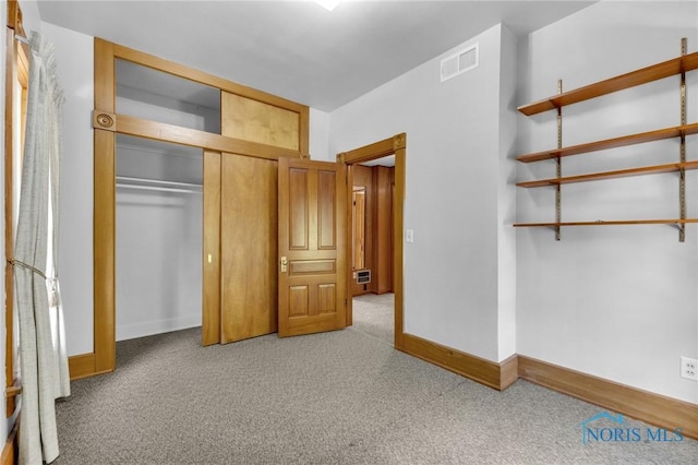 888 Columbus Ave, Fostoria, OH 44830 - unfurnished bedroom with carpet flooring, baseboards, visible vents, and a closet