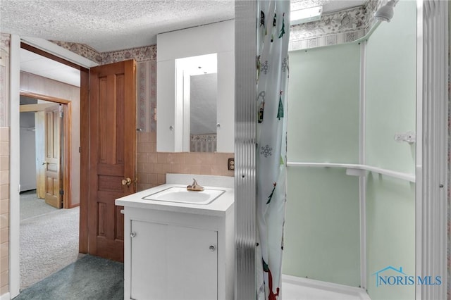 888 Columbus Ave, Fostoria, OH 44830 - full bath with vanity, tile walls, a textured ceiling, a shower stall, and backsplash