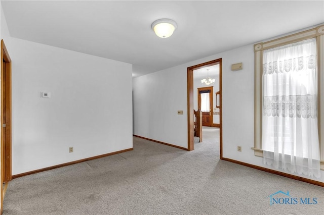 888 Columbus Ave, Fostoria, OH 44830 - empty room featuring baseboards, an inviting chandelier, and carpet