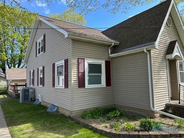 view of home's exterior featuring central AC and a yard
