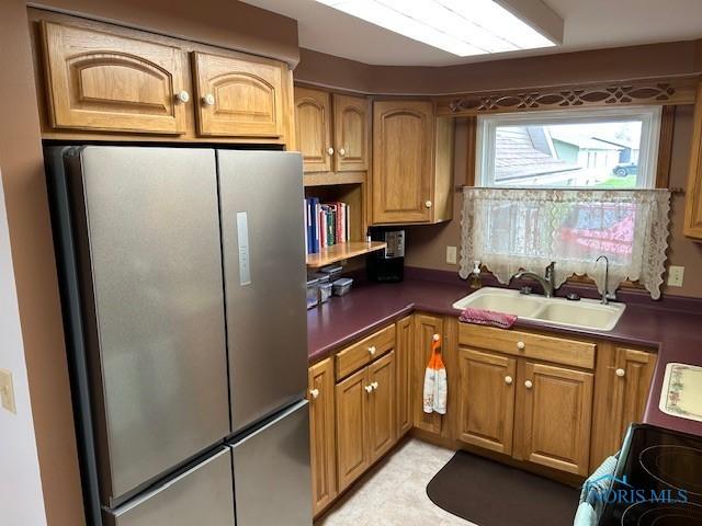 163 E Hull St, Edgerton, OH 43517 - kitchen featuring freestanding refrigerator, brown cabinetry, a sink, electric stove, and dark countertops