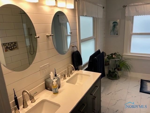 163 E Hull St, Edgerton, OH 43517 - full bath featuring a sink, double vanity, baseboards, and marble finish floor