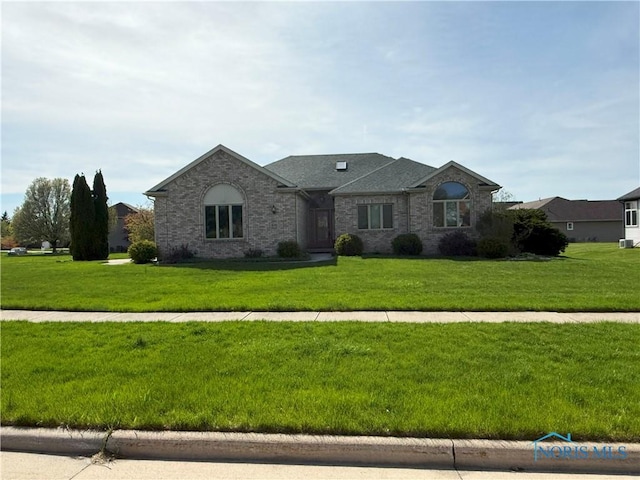 ranch-style home with brick siding, a shingled roof, and a front yard