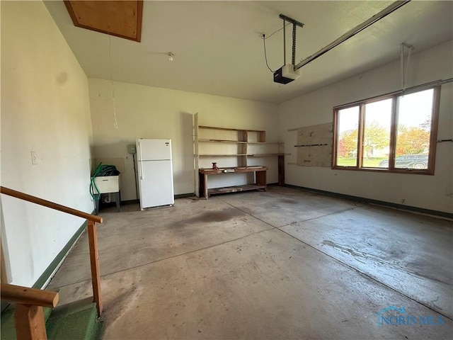 garage featuring freestanding refrigerator and a garage door opener