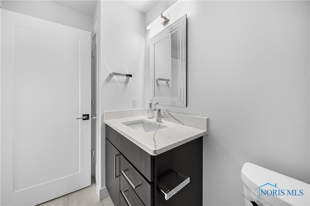 half bathroom with vanity and toilet