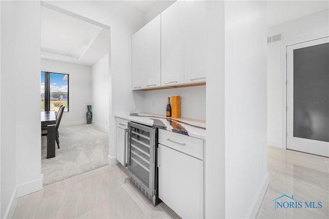 bar with baseboards, visible vents, a dry bar, and wine cooler