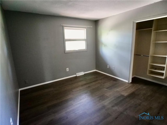 416 Donbar Dr, Bowling Green, OH 43402 - unfurnished bedroom with baseboards, a closet, dark wood-style flooring, and visible vents