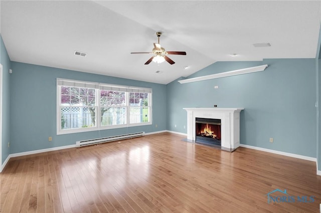 unfurnished living room with visible vents, a fireplace with flush hearth, wood finished floors, a baseboard heating unit, and a ceiling fan