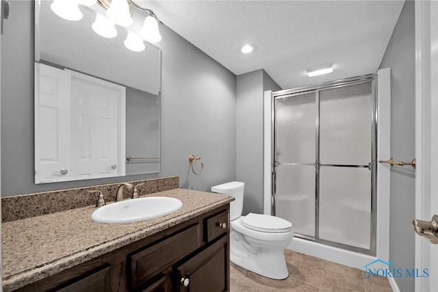 bathroom with vanity, tile patterned flooring, toilet, and a shower stall