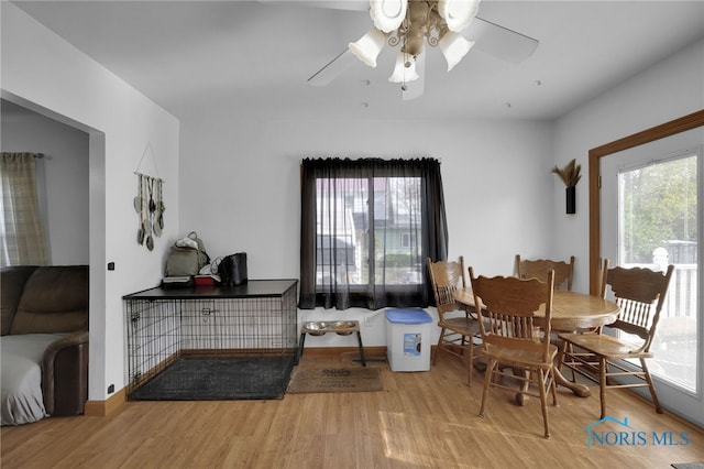dining space featuring baseboards, ceiling fan, and wood finished floors