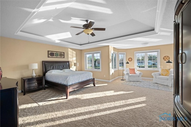 bedroom with baseboards, carpet, multiple windows, and a raised ceiling