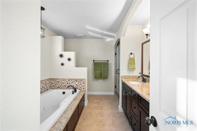 full bathroom with tile patterned flooring, vanity, baseboards, a bath, and a stall shower
