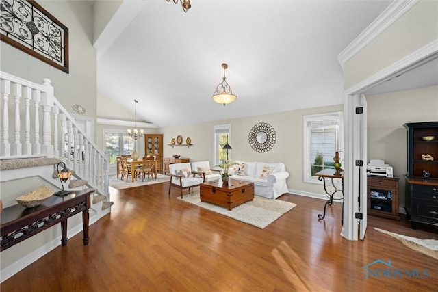 living area featuring wood finished floors, baseboards, high vaulted ceiling, a chandelier, and stairs