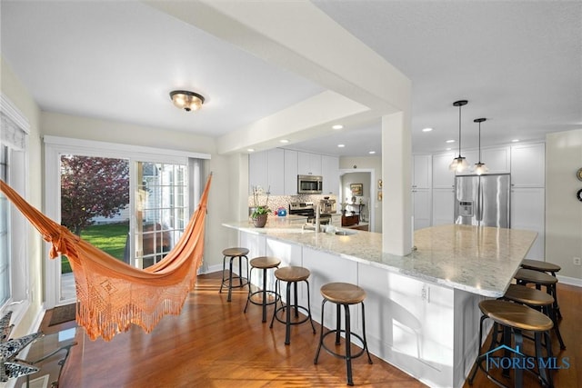 kitchen with a sink, a kitchen breakfast bar, stainless steel appliances, and a peninsula