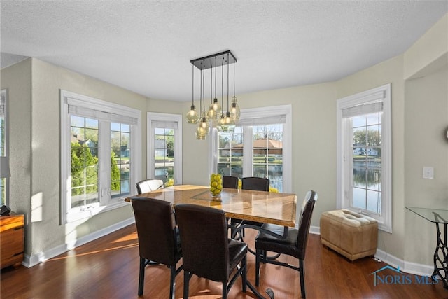 dining area with baseboards, a textured ceiling, and dark wood-style flooring