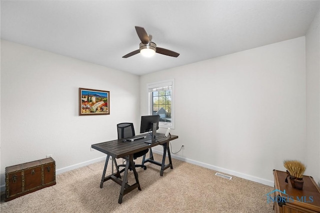 home office featuring baseboards, a ceiling fan, light colored carpet, and visible vents
