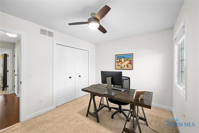 office area with baseboards, a ceiling fan, carpet flooring, and visible vents