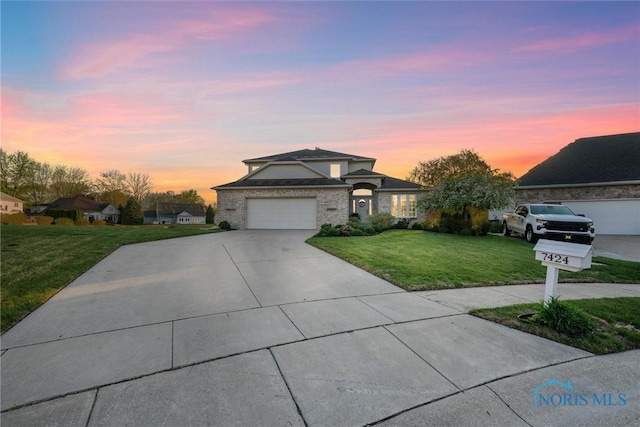 view of front of home featuring an attached garage, driveway, and a front yard