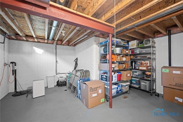 unfinished basement featuring brick wall