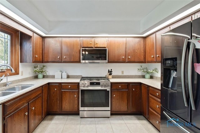 kitchen featuring light countertops, stainless steel appliances, light tile patterned floors, and a sink