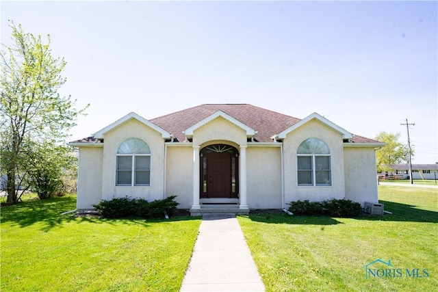 view of front of house featuring stucco siding and a front yard