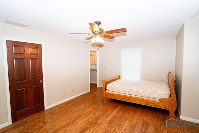 bedroom featuring visible vents, baseboards, ceiling fan, and hardwood / wood-style flooring
