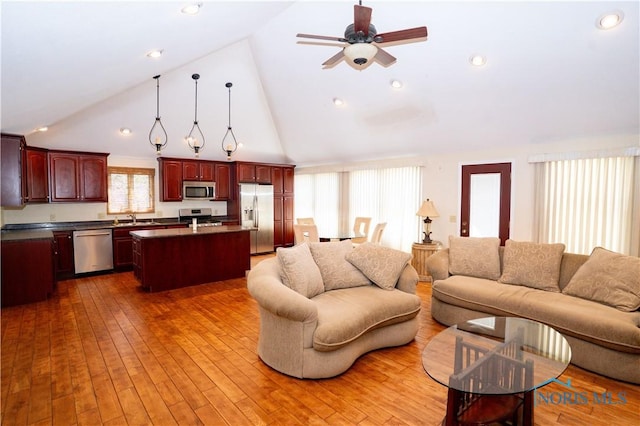 living room featuring wood-type flooring, a ceiling fan, and high vaulted ceiling