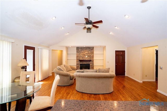 living area featuring baseboards, a ceiling fan, a fireplace, and hardwood / wood-style flooring