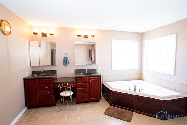 bathroom featuring a sink, tile patterned floors, a bath, and two vanities
