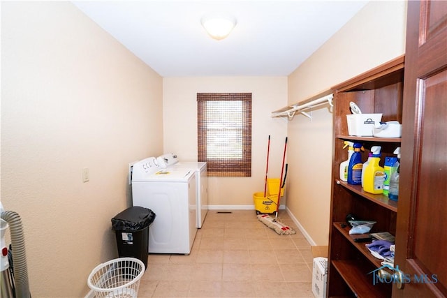 laundry area with laundry area, baseboards, independent washer and dryer, and light tile patterned floors