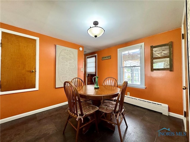 dining room with dark tile patterned flooring, baseboards, and baseboard heating