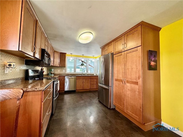 kitchen featuring decorative backsplash, a sink, appliances with stainless steel finishes, and brown cabinets