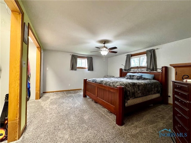 bedroom featuring baseboards, a textured ceiling, carpet, and a ceiling fan