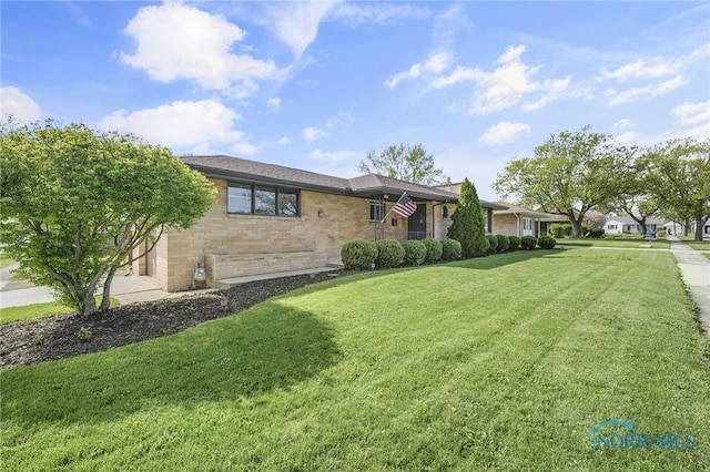 ranch-style home with brick siding and a front yard