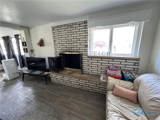 living area with wood finished floors and a wood stove