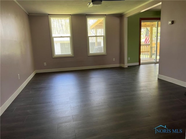 spare room with crown molding, dark wood-style floors, and plenty of natural light