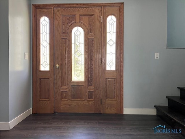 foyer entrance with baseboards, dark wood-style floors, and stairway