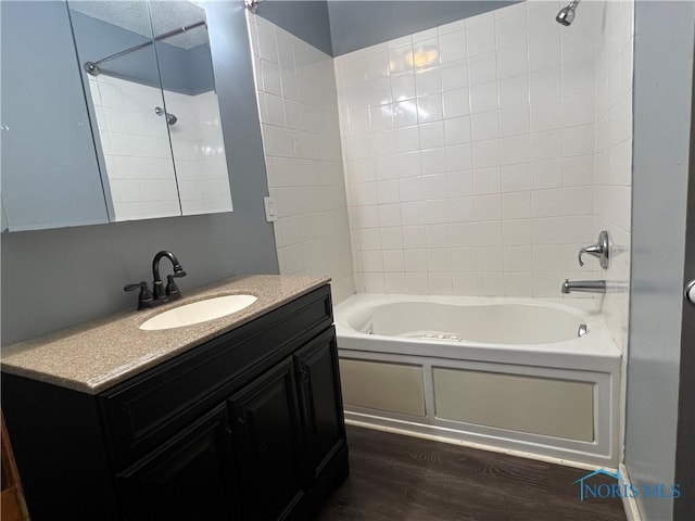 full bath with shower / bath combination, wood finished floors, and vanity