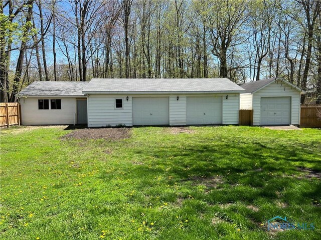 detached garage featuring fence