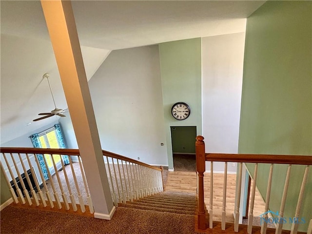 stairway with carpet floors, a ceiling fan, baseboards, and lofted ceiling