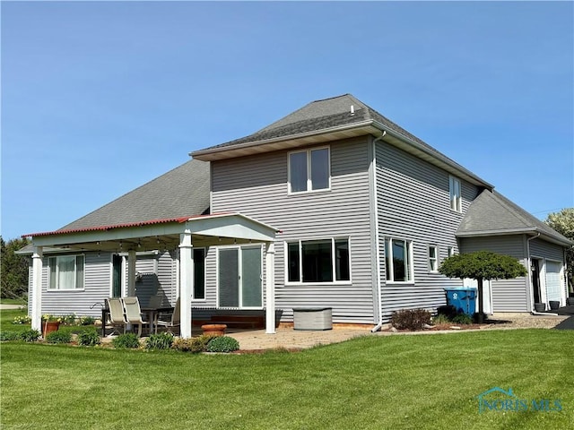 rear view of property with a yard, a patio, and a shingled roof