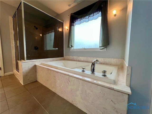 bathroom with tile patterned floors, a shower stall, and a garden tub