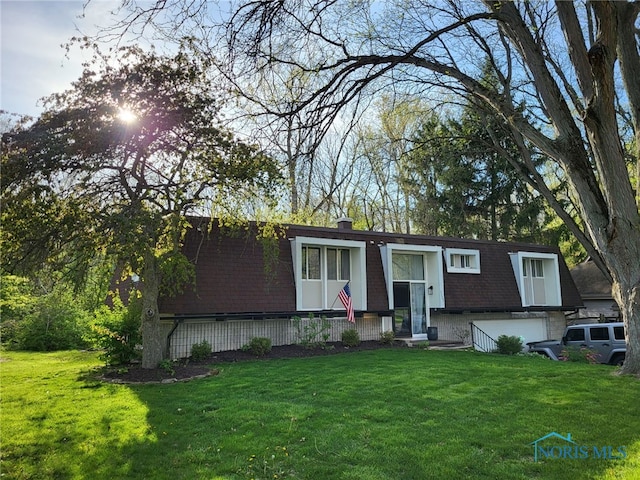 raised ranch with a front lawn, a chimney, and an attached garage