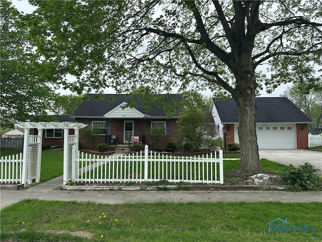 view of front of house with brick siding, a front lawn, a fenced front yard, and concrete driveway