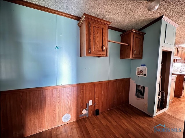 laundry room with crown molding, wood finished floors, a wainscoted wall, and hookup for a washing machine