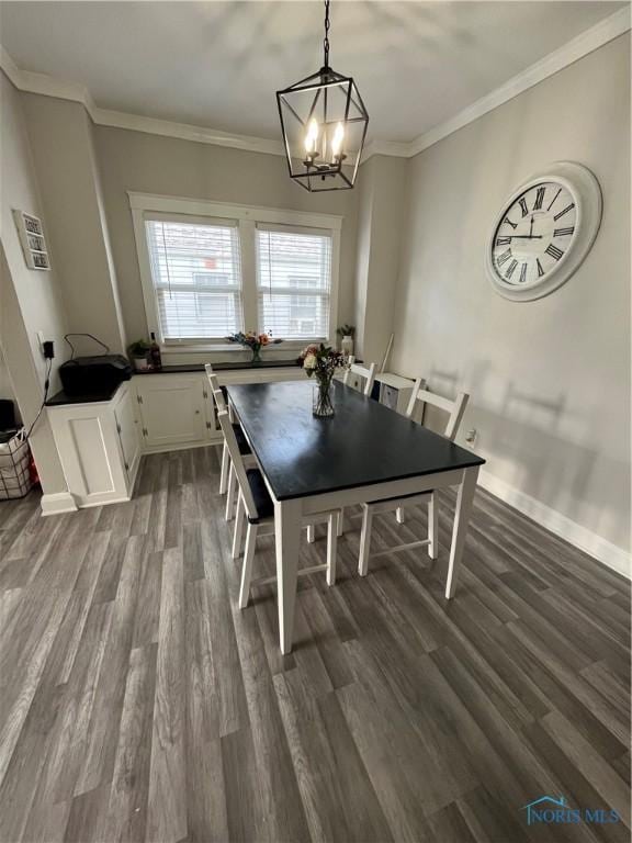 dining area featuring crown molding, a notable chandelier, and dark wood-type flooring